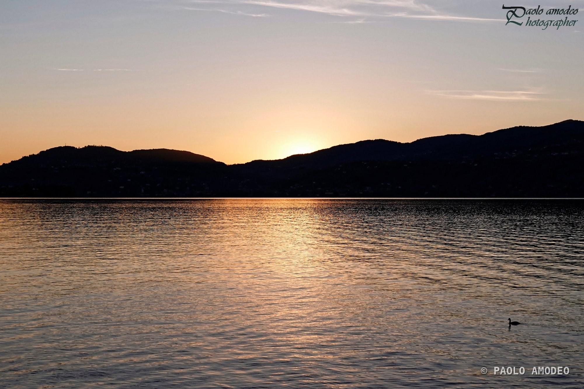 Tramonto sulle colline che si specchiano nel lago